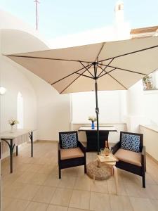 a large umbrella in a room with chairs and a table at L'Archetto romantic suite in the center of Anacapri in Anacapri