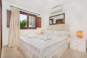 ポルト・ダ・ポリェンサにあるVilla Hibiscusの白いベッドルーム(ベッド1台、鏡付)