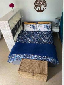 a bedroom with a bed with a blue comforter at The Hideaway at Peacock Farm in Bottesford