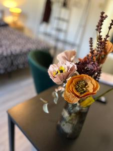 un vase rempli de fleurs assis sur une table dans l'établissement Appartamento con vista mare e parcheggio, à Trieste