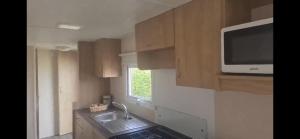 a small kitchen with a sink and a microwave at 192 Rickardos Holiday Lets in Louth