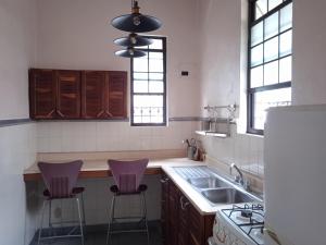a kitchen with two purple stools in front of a sink at Villa Gascue Guest Apartments in Santo Domingo