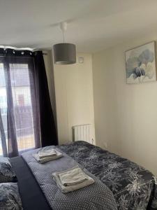 ein Schlafzimmer mit einem Bett mit zwei Handtüchern darauf in der Unterkunft Maison Goussainville - Aéroport ROISSY CHARLES DE GAULLES & PARIS in Goussainville