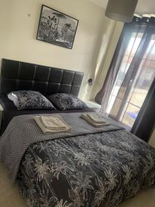 - une chambre avec un lit et 2 serviettes dans l'établissement Maison Goussainville - Aéroport ROISSY CHARLES DE GAULLES & PARIS, à Goussainville