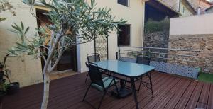 einen Tisch und Stühle auf einer Terrasse mit einem Baum in der Unterkunft Welcome, Bienvenue, Chez Charly! in Nébian