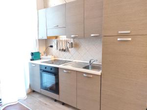 una cucina con armadi in legno e lavandino di BaGiu - Intero Appartamento Bari a Bari