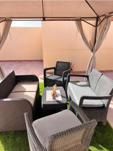 a group of wicker chairs and tables under a tent at Apartamento Los Girasoles in Corralejo