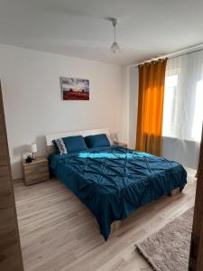 una camera con letto e piumone blu di Premium Apartament a Giroc