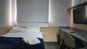 a bedroom with a bed and a desk and a television at TrevizZo São Caetano do Sul in São Caetano do Sul