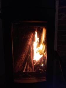 einen Kamin mit einem Feuer im Dunkeln in der Unterkunft Les hirondelles 