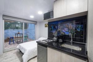una cocina con fregadero y una cama en una habitación en Las Aguas Studios, en Bogotá