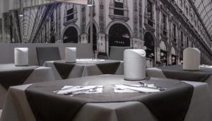 a dining room with tables and chairs and a building at Hotel Flora in Milan