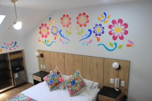 a bedroom with a bed with a flower mural on the wall at Platero Hotel in Ayacucho