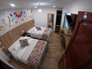 una camera d'albergo con due letti e un pianoforte di Platero Hotel ad Ayacucho