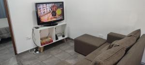 ein Wohnzimmer mit einem Sofa und einem Flachbild-TV in der Unterkunft Nuestra Casa en Paso in Paso de la Patria