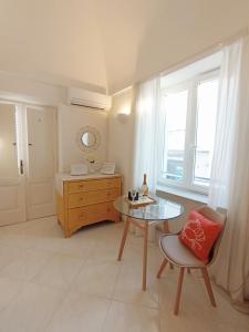 um quarto com uma mesa, uma cadeira e uma janela em L'Archetto romantic suite in the center of Anacapri em Anacapri