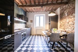 a kitchen with a table and chairs in a room at Casa Paola, eleganza nel cuore di Suvereto in Suvereto