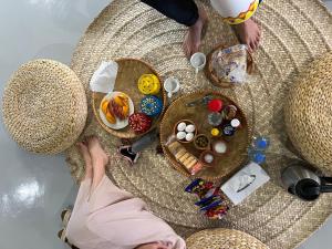 a person in a hat sitting at a table with food at Nomad inn Tiwi in Ḩillat al Ḩişn