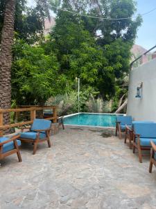 un patio con sillas y una piscina en Nomad inn Tiwi, en Ḩillat al Ḩişn