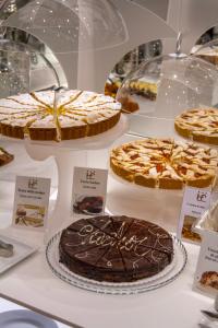 a display of cakes and pies in a display case at Hotel Flora in Milan