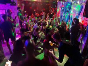 a group of people dancing at a nightclub at King Kong hostel in Da Lat