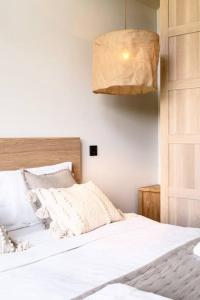 a bedroom with a bed with white sheets and a lamp at Modern Villa By The Sea in Palanga