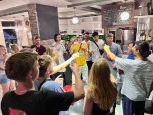 a group of people raising their hands in a crowd at King Kong hostel in Da Lat