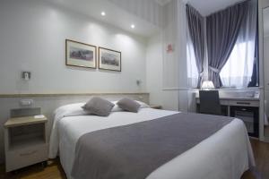 um quarto com uma cama grande e uma janela em Hotel Flora em Milão