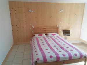 a bedroom with a bed with a pink and white comforter at Logement avec 2 chambres pour 5 personnes maxi 