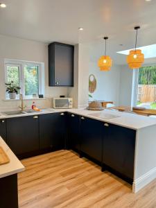 eine Küche mit schwarzen Schränken und weißen Arbeitsplatten in der Unterkunft The Old Gatehouse in Legbourne + 10 Fotos