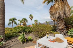 a table with a bottle of wine and a hat on it at La Villa La Palma- 1 dormitorio B in Los Barros