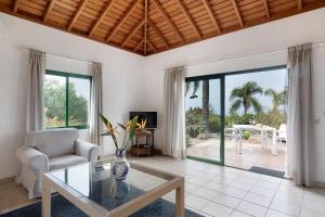 a living room with a glass table and a chair at La Villa La Palma- 1 dormitorio B in Los Barros