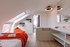 Cette chambre blanche comprend un lit et un lavabo. dans l'établissement Margriet Apart-Suites, à Gand