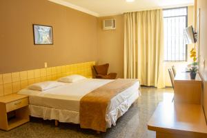 um quarto de hotel com uma cama grande e uma secretária em Hotel Diplomat em Brasília