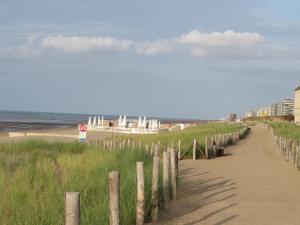 a path leading to a beach with a fence at La perle du Nord in Middelkerke