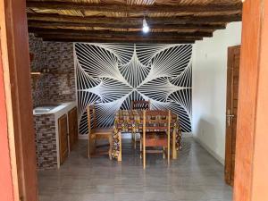 a dining room with a table and a wall at CAMPAMENTO CHEZ CAMPOS in Cap Skirring