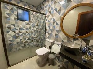 a bathroom with a sink and a toilet and a mirror at CASA VENTO SOLAR in Santana do Riacho