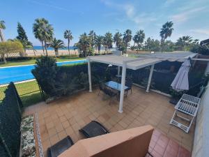a patio with an umbrella and a table and chairs at Primera línea playa in Roquetas de Mar