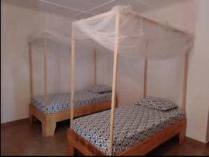 two twin beds in a room with a canopy at CAMPAMENTO CHEZ CAMPOS in Cap Skirring