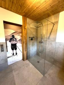 a person on skis in a bathroom with a shower at Alpflower in Halblech
