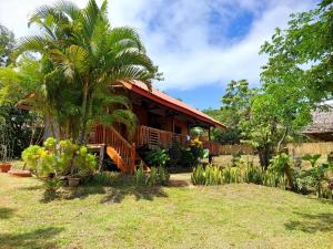 a house with a palm tree in a yard at B&R Hostel Nagtabon in Bacungan