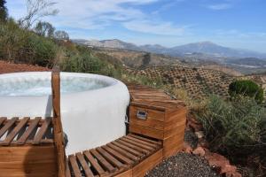 uma banheira de hidromassagem no topo de uma colina em Casa KiSi Cottage, Rural Boutique Bed & Breakfast em Málaga
