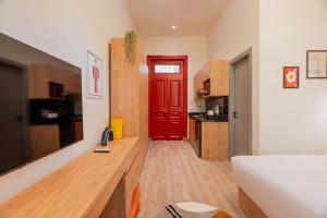 a living room with a red door and a kitchen at Brassbell studios in Zamalek in Cairo