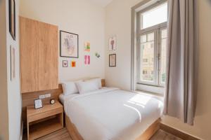 a bedroom with a white bed and a window at Brassbell studios in Zamalek in Cairo