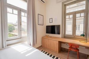a bedroom with a bed and a desk with a television at Brassbell studios in Zamalek in Cairo