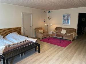 sypialnia z łóżkiem, kanapą i stołem w obiekcie Stay in Brøns w mieście Skærbæk