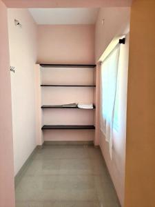 a walk in closet with shelves and a window at The Circle in Auroville