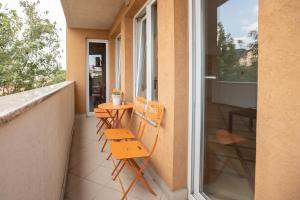 a balcony with two chairs and a table on it at Apartment DE LUXE FAMILY in Niš