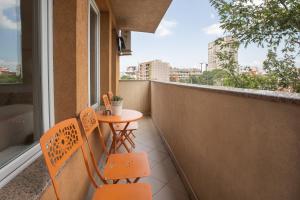 a balcony with a table and chairs and a window at Apartment DE LUXE FAMILY in Niš