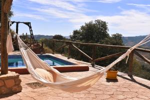 a hammock on a patio next to a pool at Casa KiSi Cottage, Rural Boutique Bed & Breakfast in Málaga